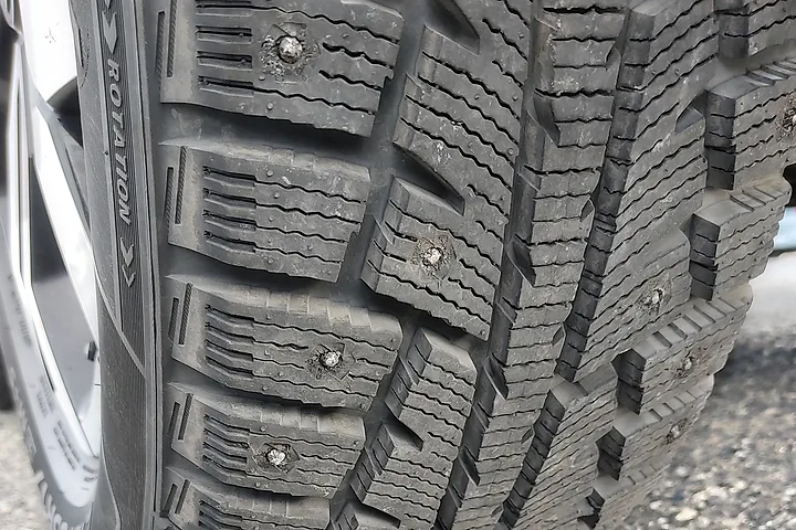 Närbild på slitbanan på ett dubbat vinterdäck