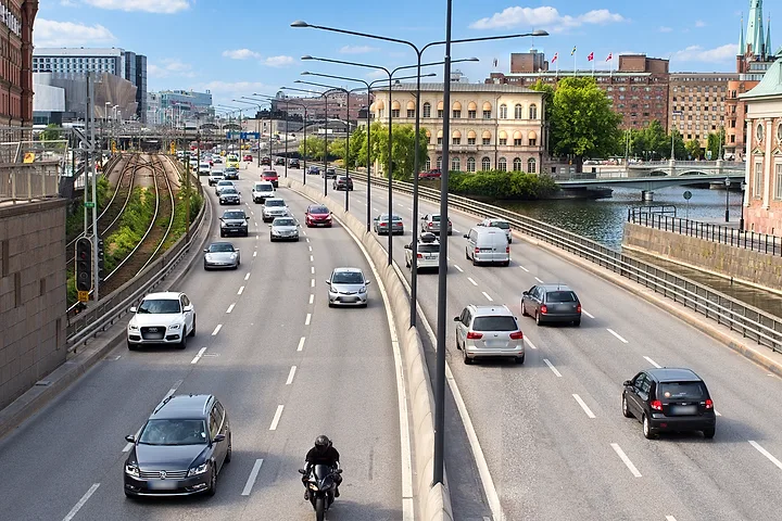 Bilar och en motorcykel på en flerfilig väg i Stockholm
